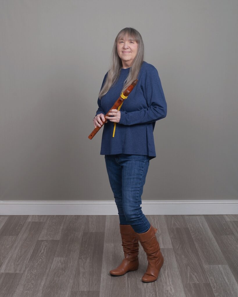 photo of Diane Wheeler Dunn standing holding a flute